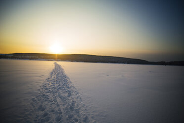 Track on snow covered field against sky - CAVF12863