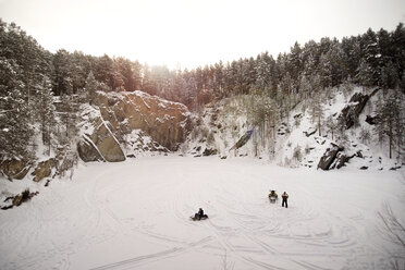 High angle view of men snowmobile on field against sky - CAVF12874