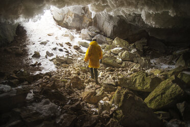 Rear view of hiker walking in cave - CAVF12882