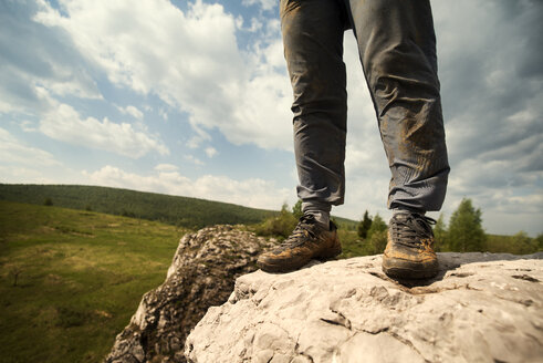 Tiefschnitt einer auf einem Felsen stehenden Person gegen den Himmel - CAVF12916