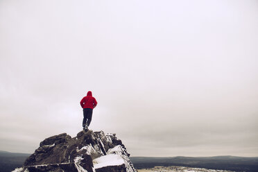 Rückansicht eines auf einem Berg stehenden Mannes gegen einen bewölkten Himmel - CAVF12985