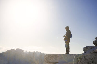 Seitenansicht eines auf einer Klippe stehenden Mannes gegen den Himmel an einem sonnigen Tag - CAVF13007