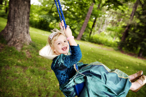 Porträt eines Mädchens, das sich auf einer Schaukel im Park vergnügt, lizenzfreies Stockfoto