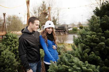 Ehepaar prüft Weihnachtsbaum am Stand - CAVF13170