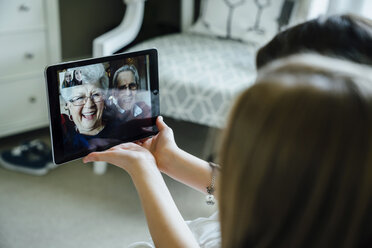 Sisters video conferencing with grandparents through tablet computer at home - CAVF13219