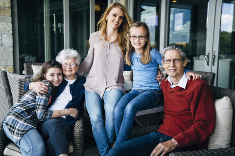 Porträt einer glücklichen Familie auf der Veranda, lizenzfreies Stockfoto