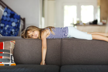 Porträt eines gelangweilten Mädchens, das zu Hause auf dem Sofa liegt - CAVF13675