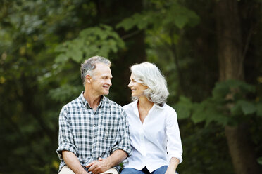 Romantisches älteres Paar im Wald sitzend - CAVF13697