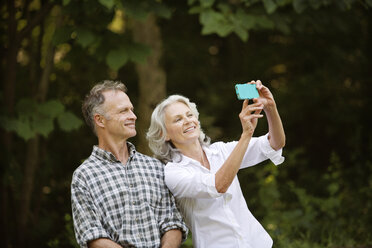 Glückliches älteres Paar macht Selfie im Wald - CAVF13699