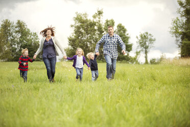 Happy family enjoying on grassy field - CAVF13765