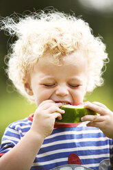 Boy with curly hair enjoying watermelon - CAVF13770