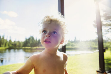 Close-up of boy at balcony against sky on sunny day - CAVF13789