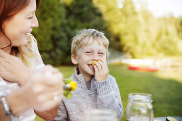 Sohn genießt mit Mutter am Picknicktisch - CAVF13800