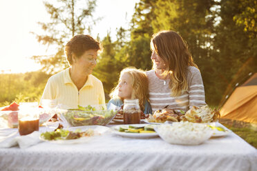 Multi generation family enjoying on picnic table - CAVF13807