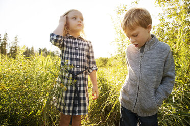 Siblings standing on grassy field - CAVF13819