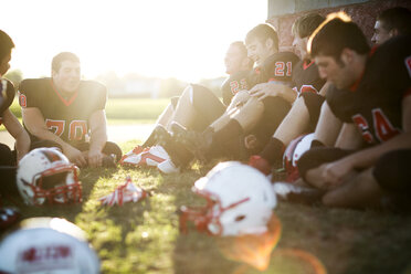 American football team relaxing on grassy field - CAVF13857