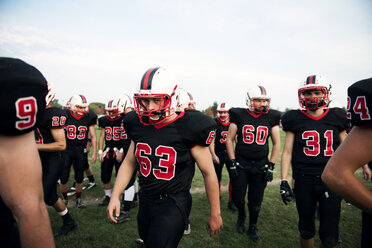 American-Football-Mannschaft, die auf dem Spielfeld gegen den Himmel läuft - CAVF13865