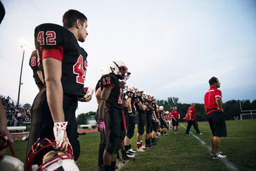 American-Football-Mannschaft auf einem Rasenfeld vor dem Himmel - CAVF13870