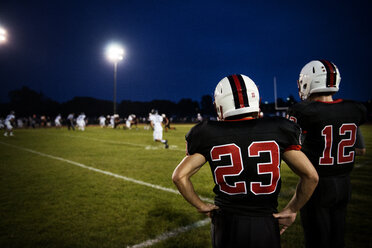 Rear view of American football players standing on Football field - CAVF13873