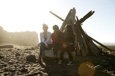 Freundinnen sitzen auf Holz am Strand - CAVF13917