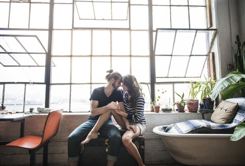 Young couple relaxing against window at home - CAVF13952