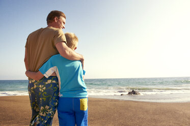 Vater und Sohn am Meer am Strand gegen den klaren Himmel - CAVF13977