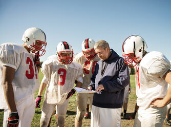 Trainer erklärt American-Football-Spielern auf dem Spielfeld - CAVF14004