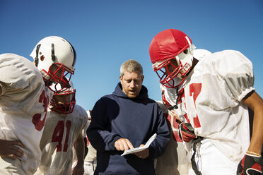 Trainer teilt American-Football-Spielern, die auf dem Feld stehen, seine Strategie mit - CAVF14005