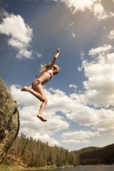 Low angle view of girl diving in lake against sky - CAVF14122