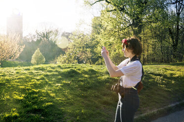 Seitenansicht einer Frau beim Fotografieren im Park - CAVF14183