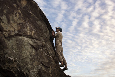 Niedriger Blickwinkel von Mann Klettern gegen Himmel - CAVF14214