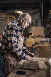 Älterer Arbeiter sucht Werkzeuge in der Werkstatt - CAVF14396