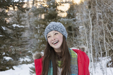 Happy girl in warm clothing looking away - CAVF14479