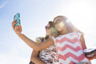 Low-Winkel-Ansicht von Teenager-Mädchen nehmen selfie gegen Himmel - CAVF14482