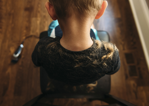Rückansicht eines Jungen, der auf einem Friseurstuhl sitzt, lizenzfreies Stockfoto