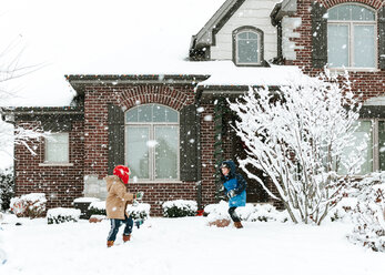 Glückliche Brüder spielen mit Schnee im Garten - CAVF14556