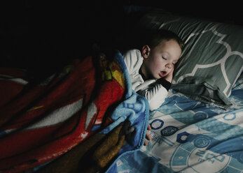 Hoher Blickwinkel auf einen Jungen, der in der Dunkelkammer zu Hause auf dem Bett schläft - CAVF14590