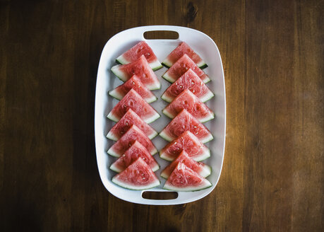 Draufsicht auf Wassermelonenscheiben, die in einem Tablett auf einem Holztisch serviert werden - CAVF14610