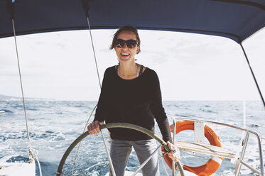 Lächelnde Frau fährt Boot auf dem Meer - CAVF14644