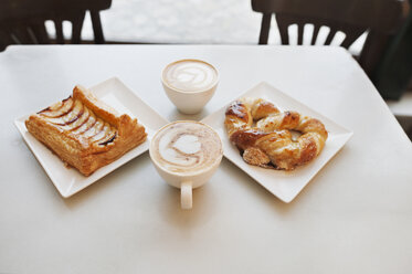 Hohe Winkel Ansicht von Cappuccino und Gebäck auf dem Tisch im Café - CAVF14648