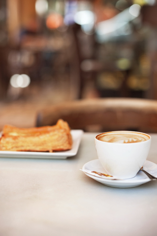 Cappuccino und Gebäck auf dem Tisch im Café serviert, lizenzfreies Stockfoto