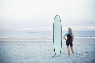 Rückansicht einer Surferin mit Surfbrett am Strand von Delray - CAVF14725