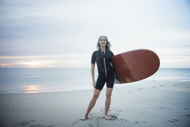 Porträt einer selbstbewussten Surferin mit Surfbrett am Delray Beach in voller Länge - CAVF14727