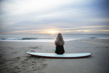 Rückansicht einer Surferin auf einem Surfbrett am Delray Beach bei Sonnenuntergang - CAVF14729