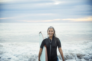 Porträt einer glücklichen, nassen Surferin mit Surfbrett am Delray Beach - CAVF14736