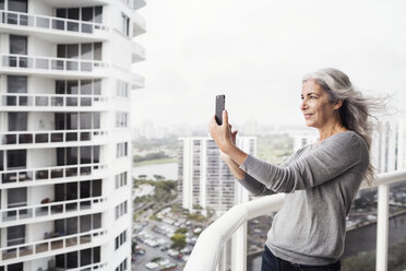 Mature woman taking selfie on balcony - CAVF14777