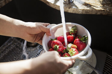 Cropped image of hands washing strawberries in colander - CAVF14933