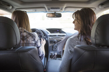 Rear view of mother and daughter travelling in car - CAVF14959