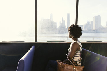 Seitenansicht einer Frau mit Blick auf die Stadt vom Bootsfenster aus - CAVF15048