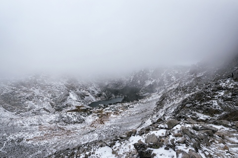 Landschaftlicher Blick auf schneebedeckte Berge bei nebligem Wetter, lizenzfreies Stockfoto